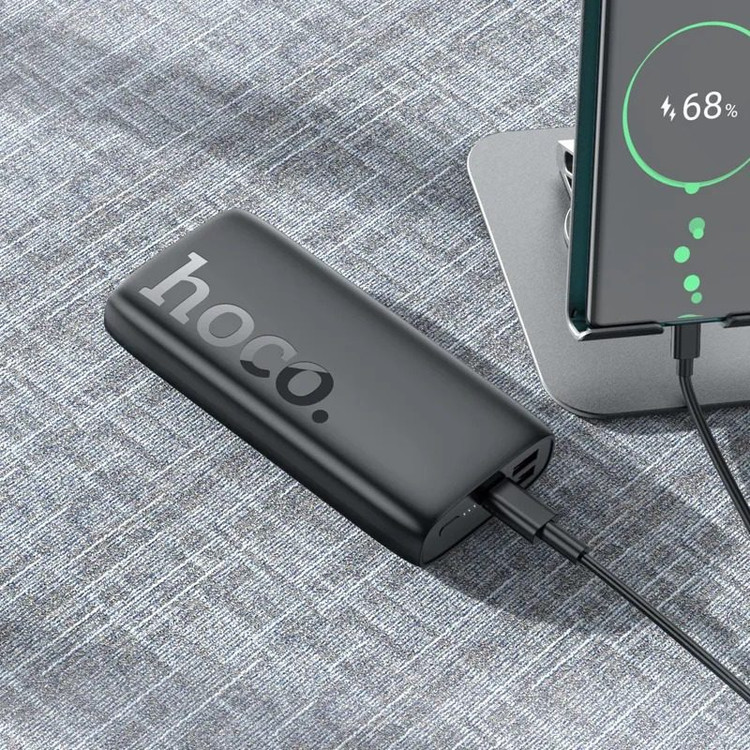 نمایی از پاوربانک هوکو J122A در حال شارژ گوشی هوشمند با نمایشگر LED فعال و طراحی مدرن